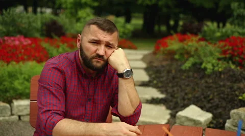 Pensive man is sitting in the park Stock Footage 65814968