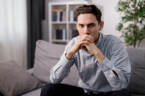 Pensive man on sofa Stock Photos
