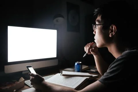 Pensive man studying with blank screen computer and smartphone Stock Photos