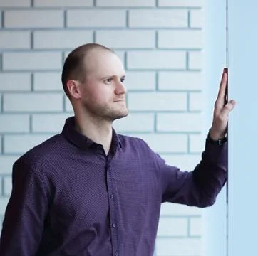 Pensive man thinking of something behind venetian blind Stock Photos