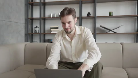 Pensive Man Thinking While Working Remotely With Laptop In Modern Home Interior 스톡 동영상 304581872