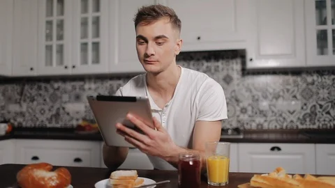 Pensive Man Using Tablet in Kitchen Видео 103828678