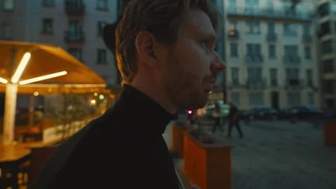 Pensive man walking thoughtfully through a city square at night Vídeo Stock 346384420