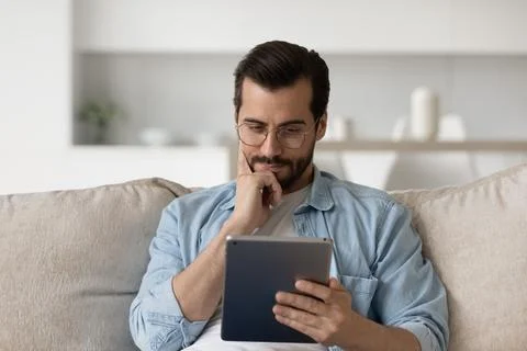 Pensive man work on tablet at home thinking Stock Photos