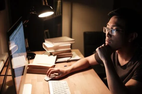 Pensive man working with computer and thinking in the evening Stock-Fotos