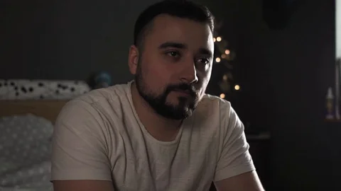 Pensive middle-aged man with a beard watching tv at home Stock-Footage 126111253