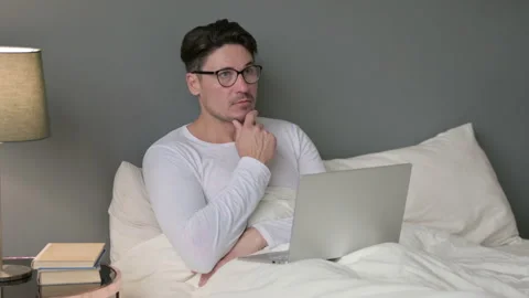 Pensive Middle Aged Man with Laptop Thinking in Bed 스톡 동영상 142373741