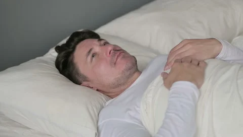 Pensive Middle Aged Man Laying Awake in Bed 스톡 동영상 142369619