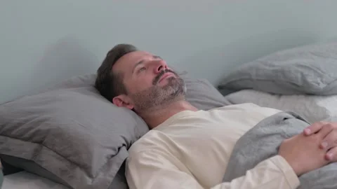 Pensive Middle Aged Man Lying in Bed Stock Footage 287899190