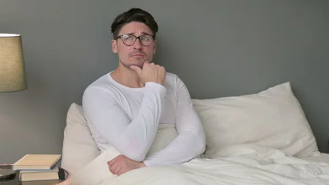 Pensive Middle Aged Man Sitting in Bed Thinking Video stock 142374187