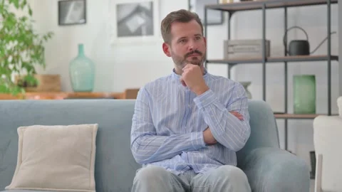 Pensive Middle Aged Man Sitting on Sofa at Home Stock Footage 287897602