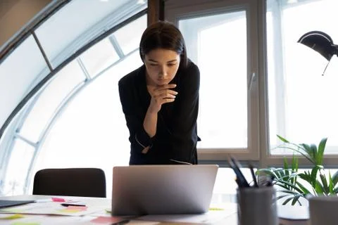 Pensive mixed race lady data analyst looking on laptop screen Stock Photos