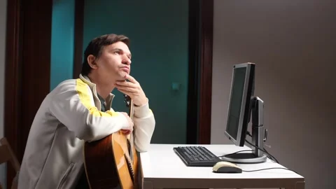 Pensive musician composing music with computer and guitar Stock-Footage 308967764