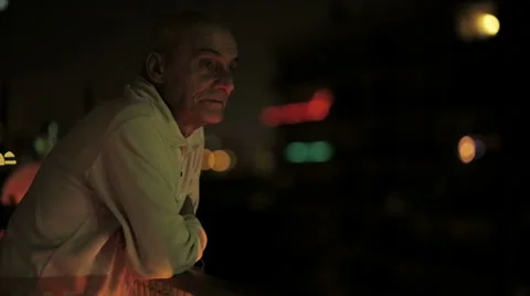 Pensive old man thinks the new year on the terrace at night Stock Footage 33404355
