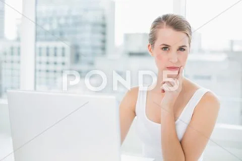 Pensive pretty blonde using her laptop Stock Photos