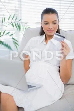 Pensive pretty woman buying online using laptop Stock Photos