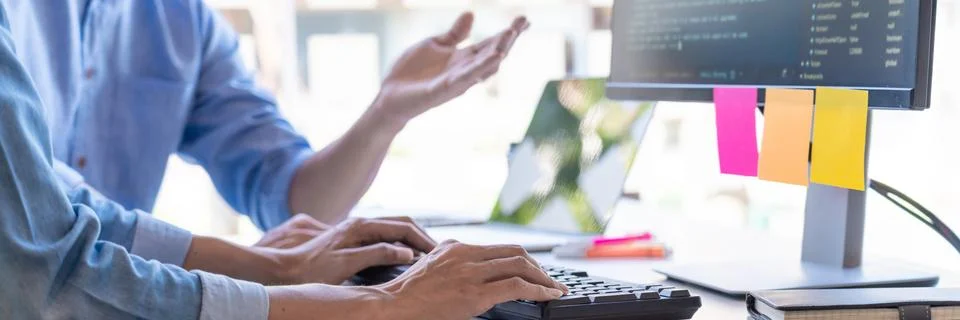 Pensive programmer working on on desktop pc programming code technologies or Foto stock