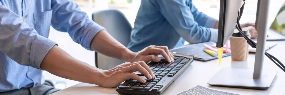 Pensive programmer working on on desktop pc programming code technologies or Foto stock