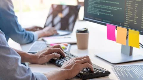 Pensive programmer working on on desktop pc programming code technologies or 스톡 사진