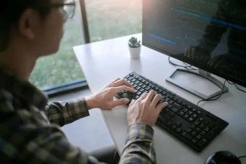 Pensive programmer working on desktop pc programming code technologies or web Photos