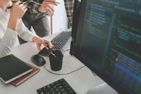 Pensive programmer working on desktop pc programming code technologies or web Foto stock