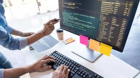 Pensive programmer working on on desktop pc programming code technologies or 写真素材