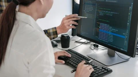 Pensive programmer working on desktop pc programming code technologies or web 库存照片