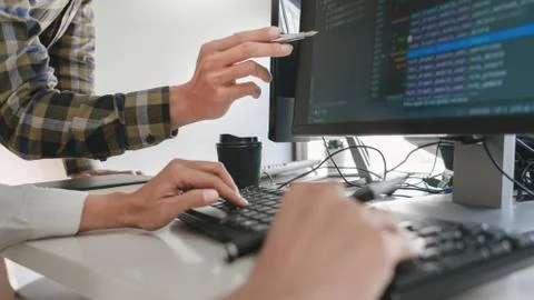 Pensive programmer working on desktop pc programming code technologies or web Stockfoto's
