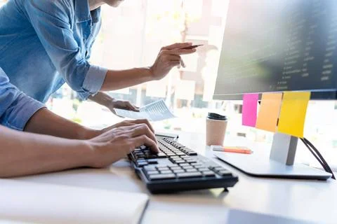 Pensive programmer working on on desktop pc programming code technologies ... Stockfoto's