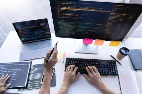 Pensive programmer working on on desktop pc programming code technologies o.. Stockfoto's