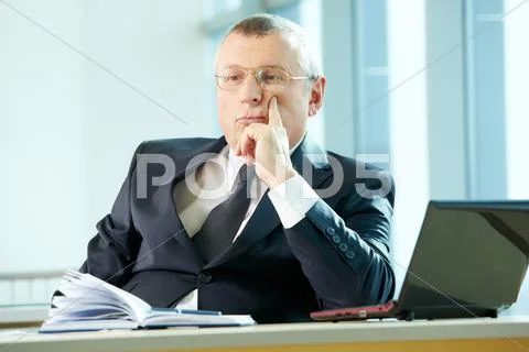 Pensive senior business leader concentrating at workplace Stock Photos