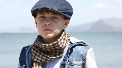 Pensive serious boy is looking forward and to the side of the sea 스톡 동영상 49922235