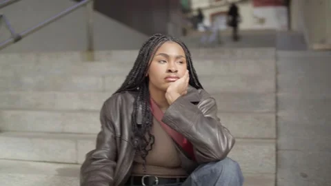 Pensive student takes a break on steps, reflecting on life's complexities Stock Footage 307019125