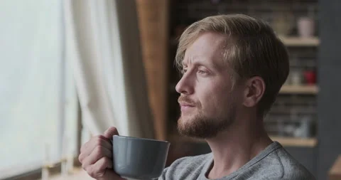 Pensive stylish man dreaming thinking about future drinking hot beverage from Video stock 165869748