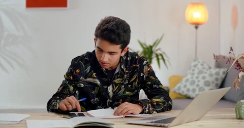 Pensive tired young student guy calculating math exercise using smartphone at Stock Footage 120946585
