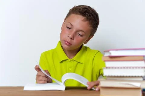 Pensive tween boy reading book at home Stock Photos