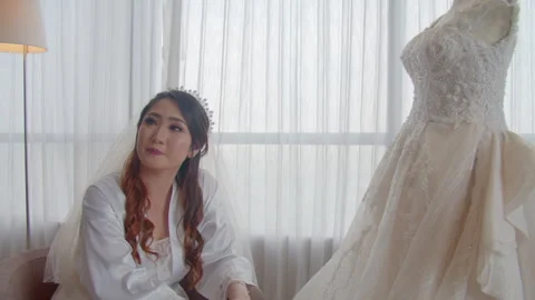Pensive Veiled Bride Preparing In Hotel Room Next To Dress Видео 333358648