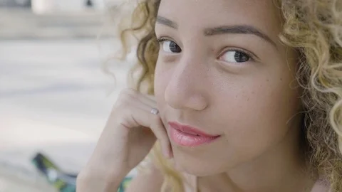 Pensive woman starting smiling sitting alone in the city Stock Footage