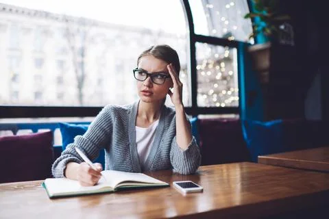 Pensive woman taking notes in notepad Stock Photos
