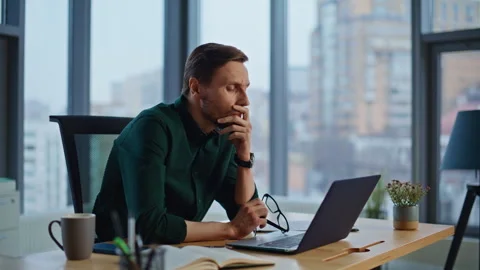 Pensive worker thinking issues looking laptop in office closeup. Serious man Stock Footage 340236800