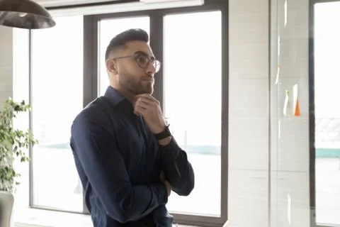 Pensive young arab middle eastern ethnicity young businessman solving problem. Stock Photos