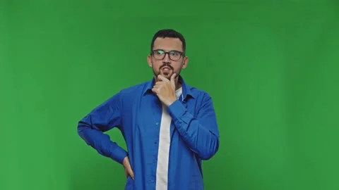 Pensive young bearded man looking for solutions to problems over green Stock Footage 169998943