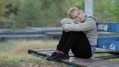 Pensive young girl child sitting alone i... | Stock Video