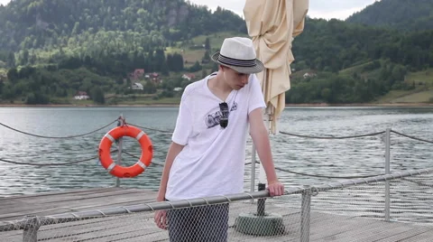 Pensive young man, pier, sad teenage boy, lake, mountain, nature Stock Footage 46250438
