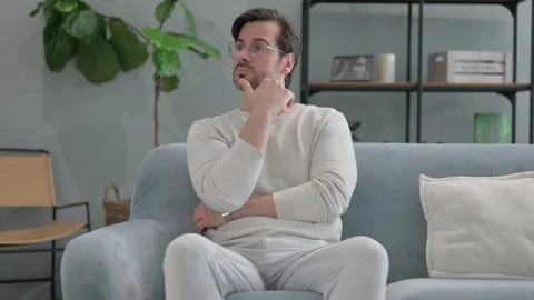 Pensive Young Man Sitting on Sofa Video stock 286159651