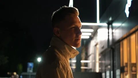 Pensive young man standing back to camera rotetes to it on the street near the Stock Footage 108123143