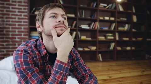 Pensive young man thinking and having an idea in home interior Video stock 84805313