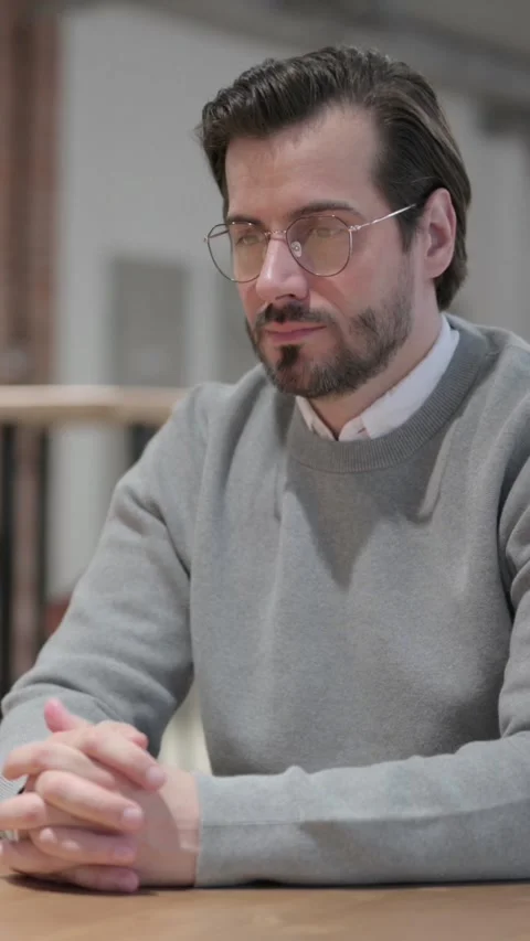 Pensive Young Man Thinking while Sitting in Café, Vertical Video Stock Footage 339581021