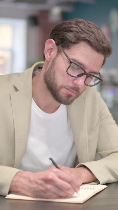 Pensive Young Man Writing on Paper, Thinking , Vertical Video Video stock 342007264