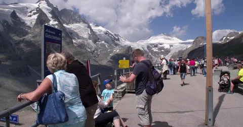 People admiring the view at mountain top with a glacier in Austria Stock Footage 79899259